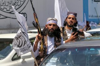 Des Afghans brandissent des drapeaux de l'Emirat islamique d'Afghanistan à l'occasion du deuxième anniversaire de la prise de contrôle du gouvernement afghan par les talibans, à Kaboul mardi.